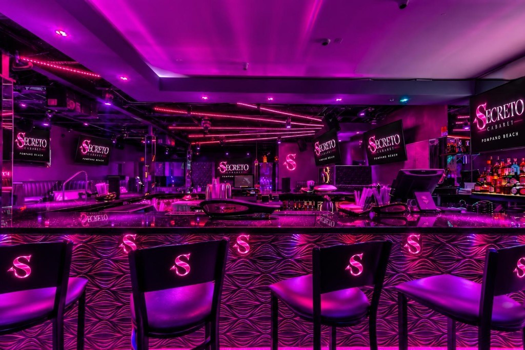 Secreto Cabaret bar with monogram stools and a mirrored bottle wall