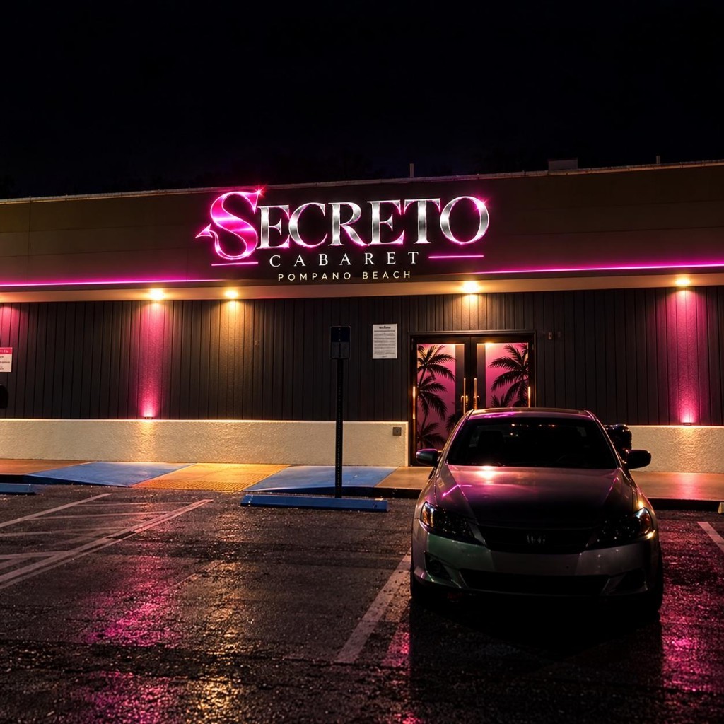 Secreto Cabaret neon sign glowing over a wet parking lot at night