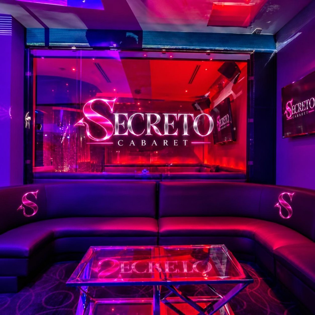 Private booth with a curved leather sofa and the Secreto logo on glass